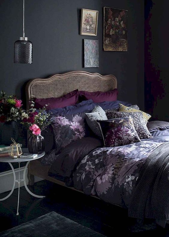 Romantic Black Bedroom Caned Bed - 20 Stunning Rattan Beds & Headboard Ideas For The Bedroom: A black bedroom with a beautiful french styled caned bed layered with purple and black bedding. Styled with a nightstand with flowers and art work above the bed. #rattanbedhead #rattanbedheadstyling #canedheadboardbedroom #rattanbedroomideas #blackbedroom #blackbedroomdesign #romanticblackbedroom #frenchrattanbed #frenchstylerattanbed