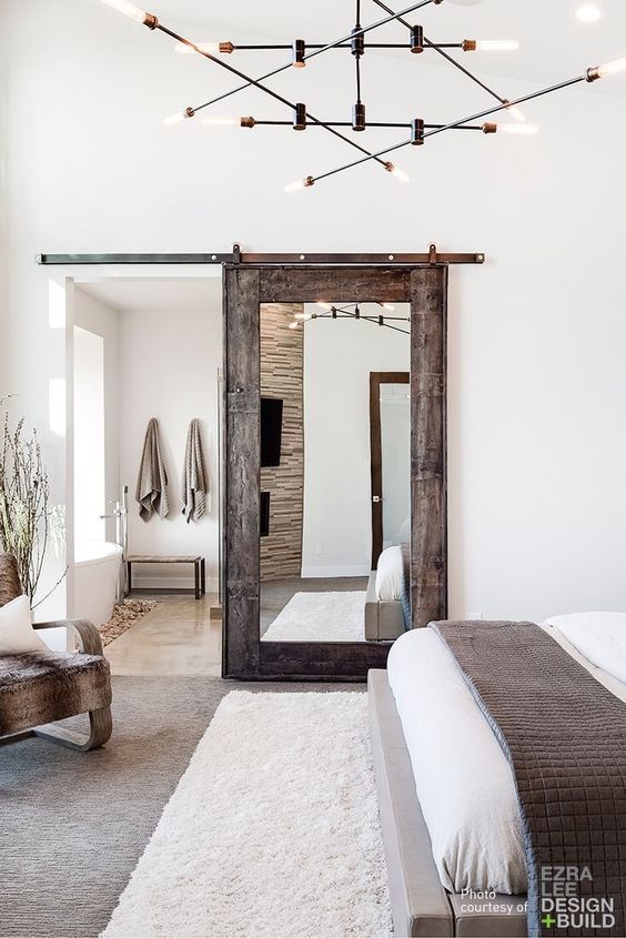 Mirrored Barn Door Dividing Bathroom From Bedroom