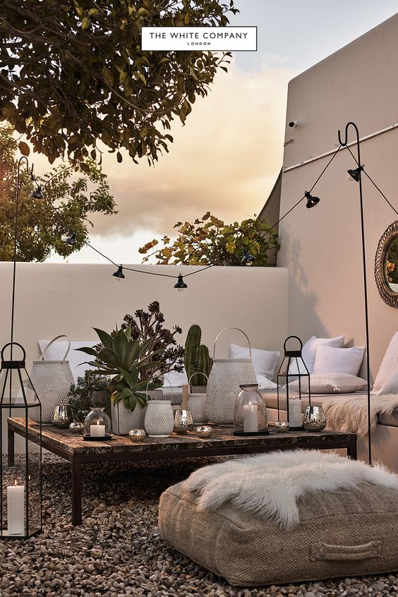 The White Company Outdoor Courtyard Seating Area - Using Garden Lanterns: 10 Favourites: A beautiful courtyard garden hosting idea from The White Company campaign. Using a score of lanterns as a decorative table scape as the central focal point of the seating area. @chloedominik #lanterns #lanternsdecor #gardenlanterns #gardenpartydecorations #gardenlanternoutdoor #gardenlanternideas #gardenlightingideas #thewhitecompany #courtyardgardenideas