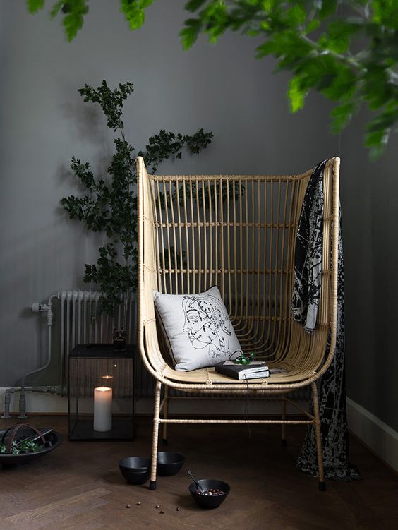 A high back rattan chair styled in a moody Japandi interior with black decor accessories and plants. An enclosed like single seat perfect for some alone time. #rattanchair #styledrattanchair #japandidecor #moodyinteriors #rattanhighbackchair @chloedominik