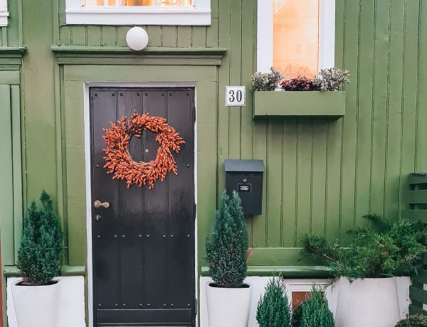 Green Home Exterior - A Gorgeous Norwegian Home Tour You'll Fall In Love With: The green exterior of a homely and gorgeous Scandinavian home. Painted a forest green with box planters below the windows and a black door. Home of Vibeke Sommerbak of Vib Interior #scandinavianinterior #scandinavianexteriorhouse #greenhouseexterior #greenhouseexteriorpaint