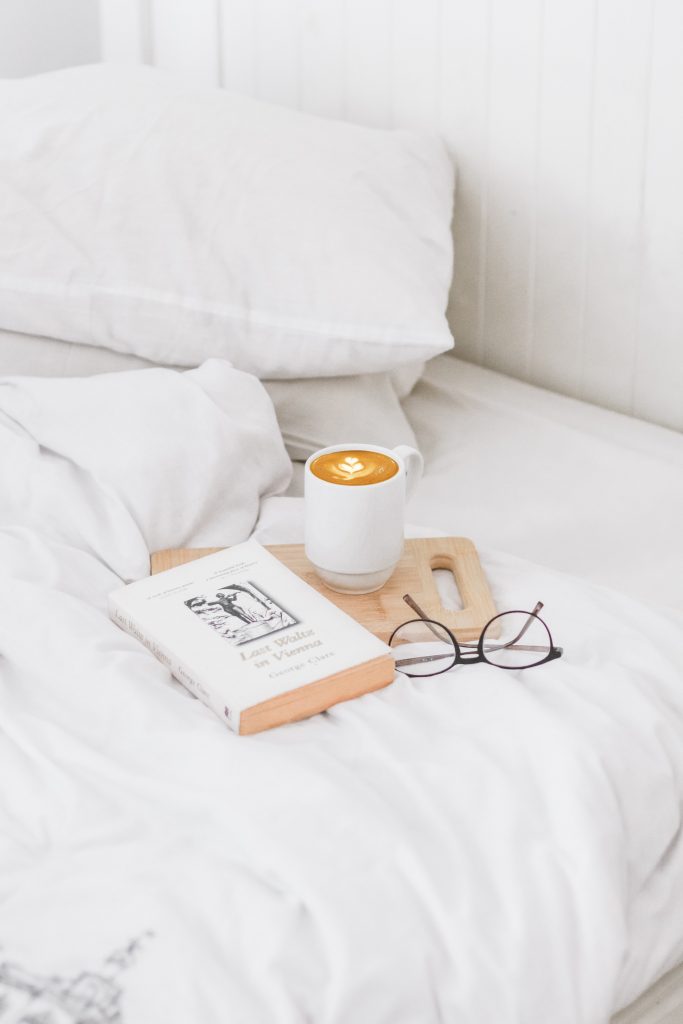 White Bed Linens - 38 Amazing Self Care Ideas To Do Around The Home: White bed linens set with a book and coffee set for a relaxing time of self care at home. Here are some other self care ideas at home, including a free download self care checklist. #selfcare #selfcareathome #whitebedding #selfcareideas #selfcarechecklist #freedownload