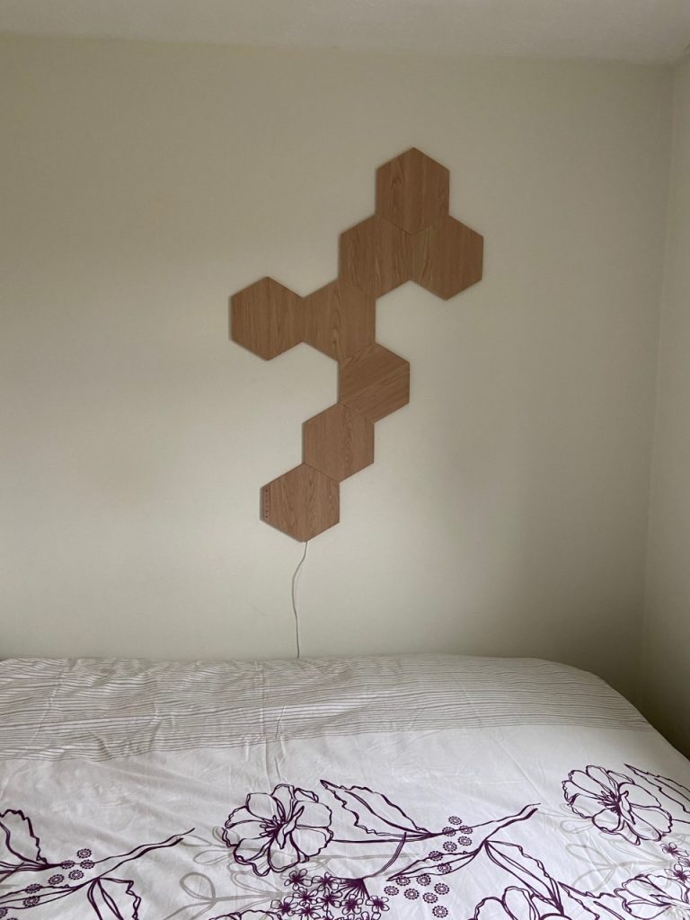 Nanoleaf Elements - wood style hexagon panel design in the bedroom. Lights off, just design wall layout.